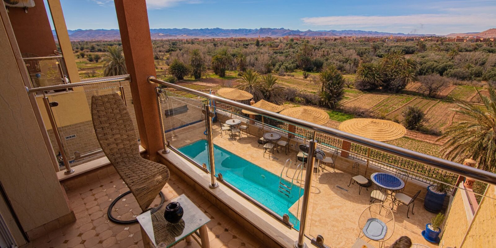 Vue piscine et palmeraie depuis la terrasse privative